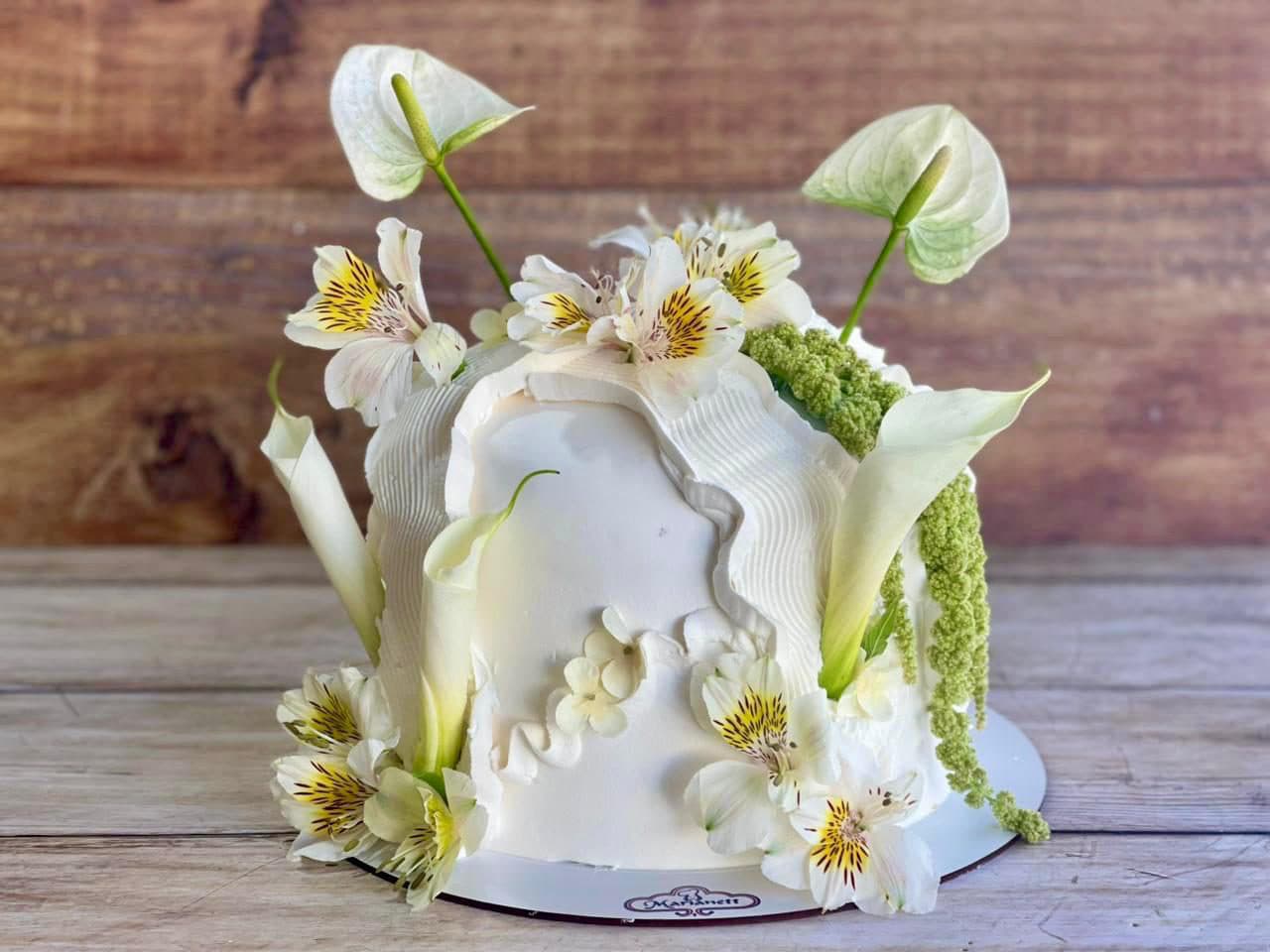 Pastel blanco decorado con alcatraces y flores blancas