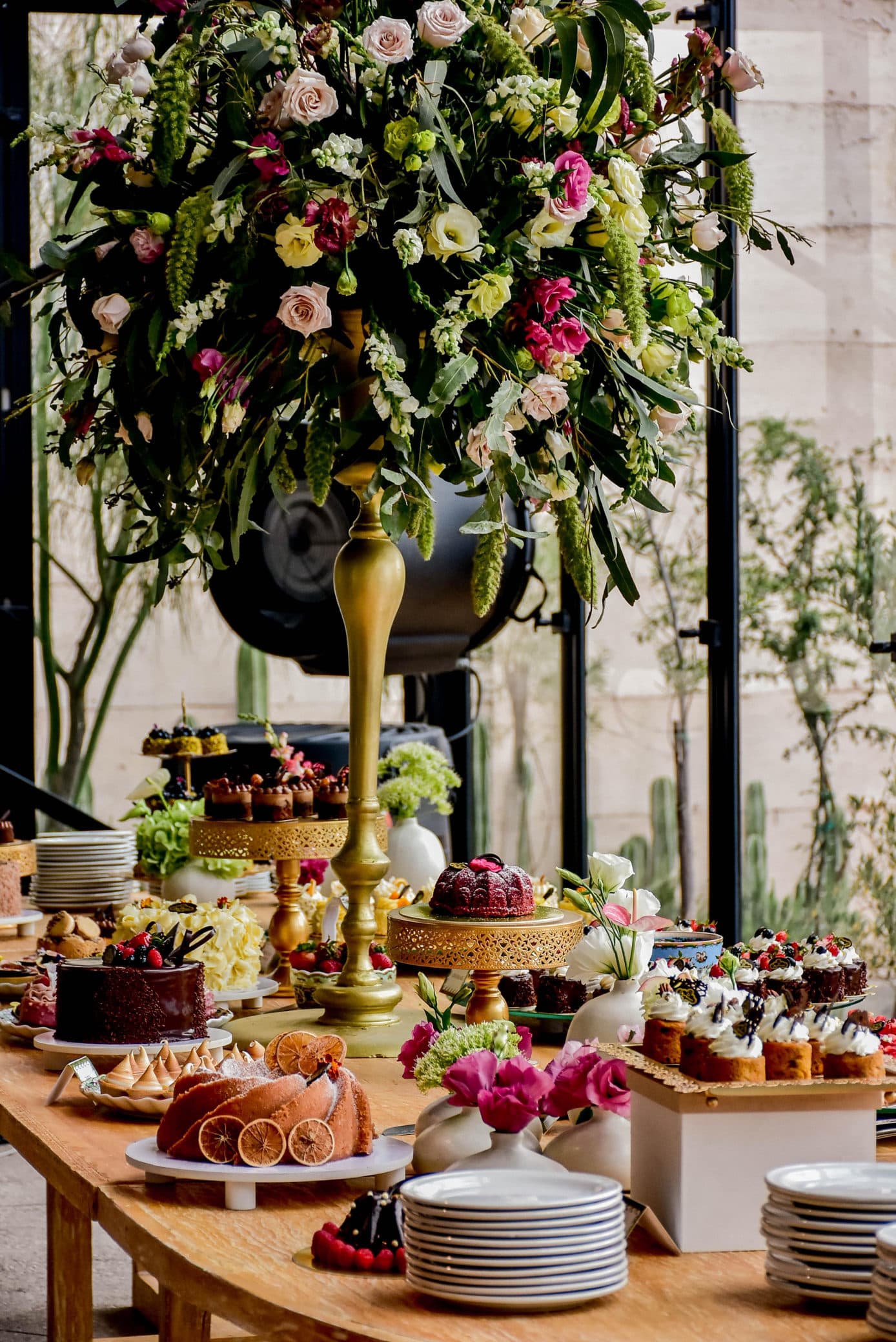 Mesa de postres con un gran arreglo de flores al centro