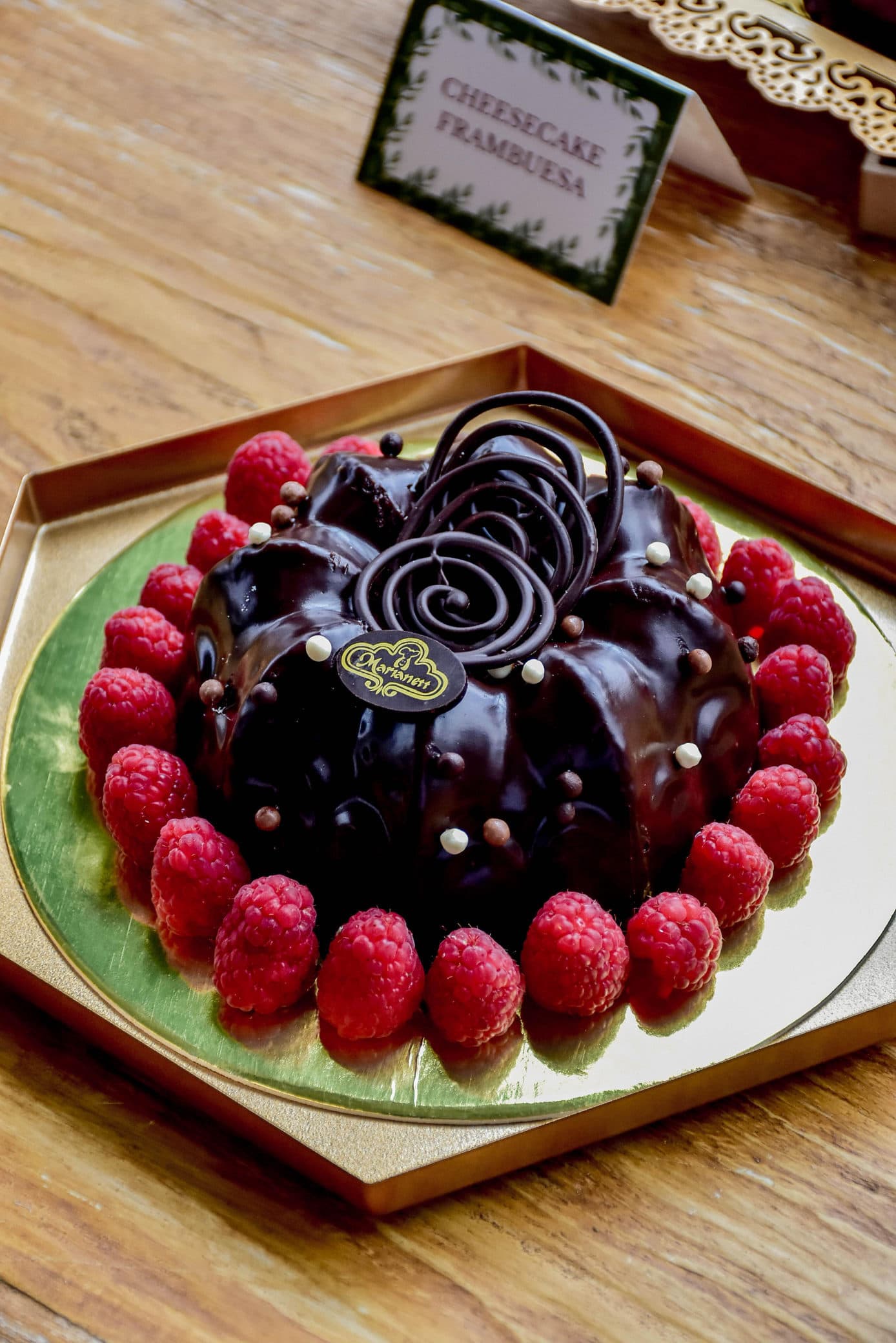 Pastel de chocolate rodeado de frambuesas